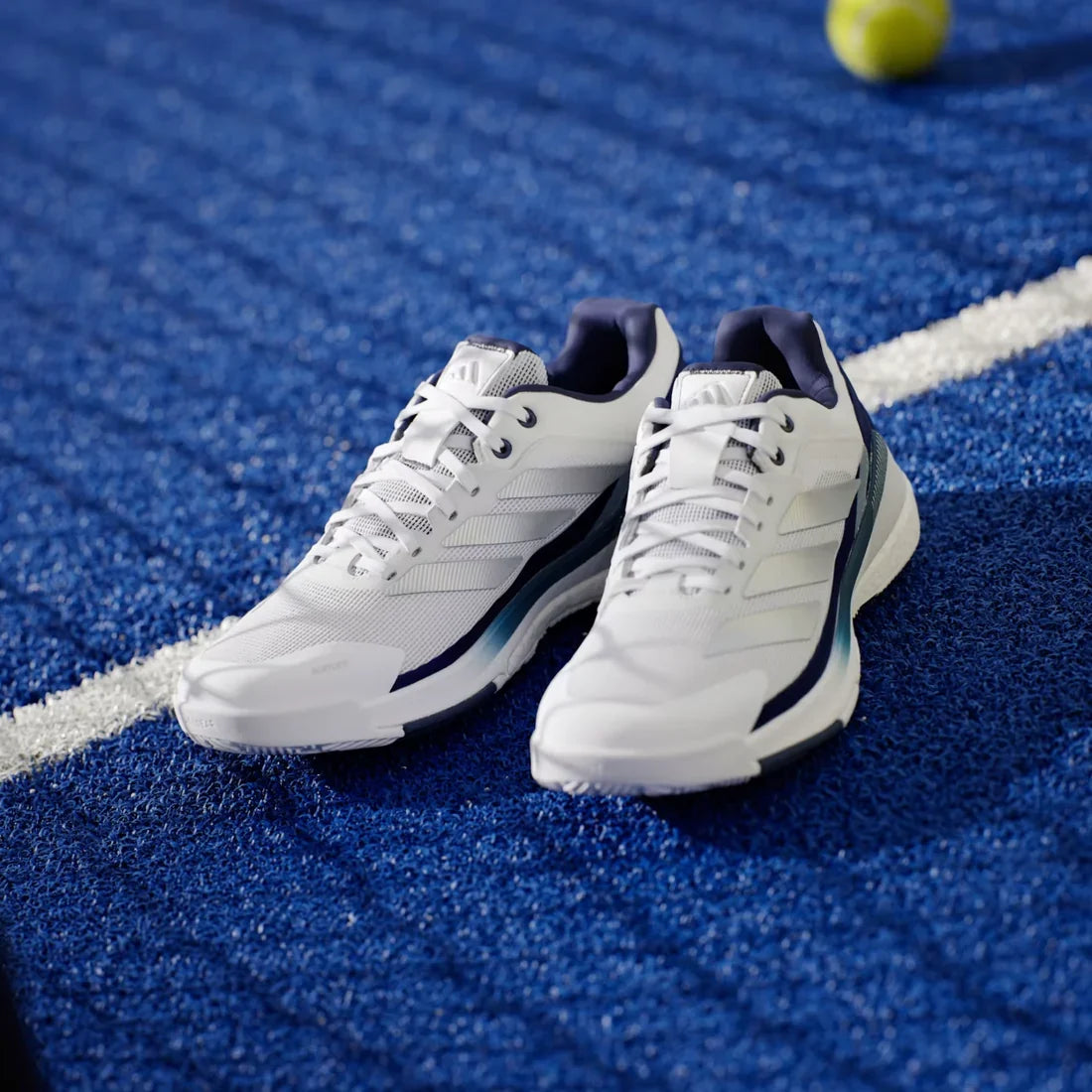 Adidas Crazyquick Boost men's padel shoes (White/Dark Blue) - pair from the front on a blue court