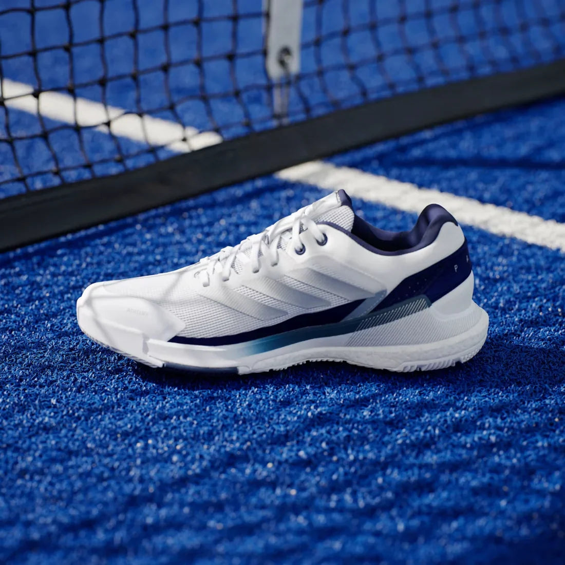 Adidas Crazyquick Boost men's padel shoes (White/Dark Blue) - inner side view on court beside the net