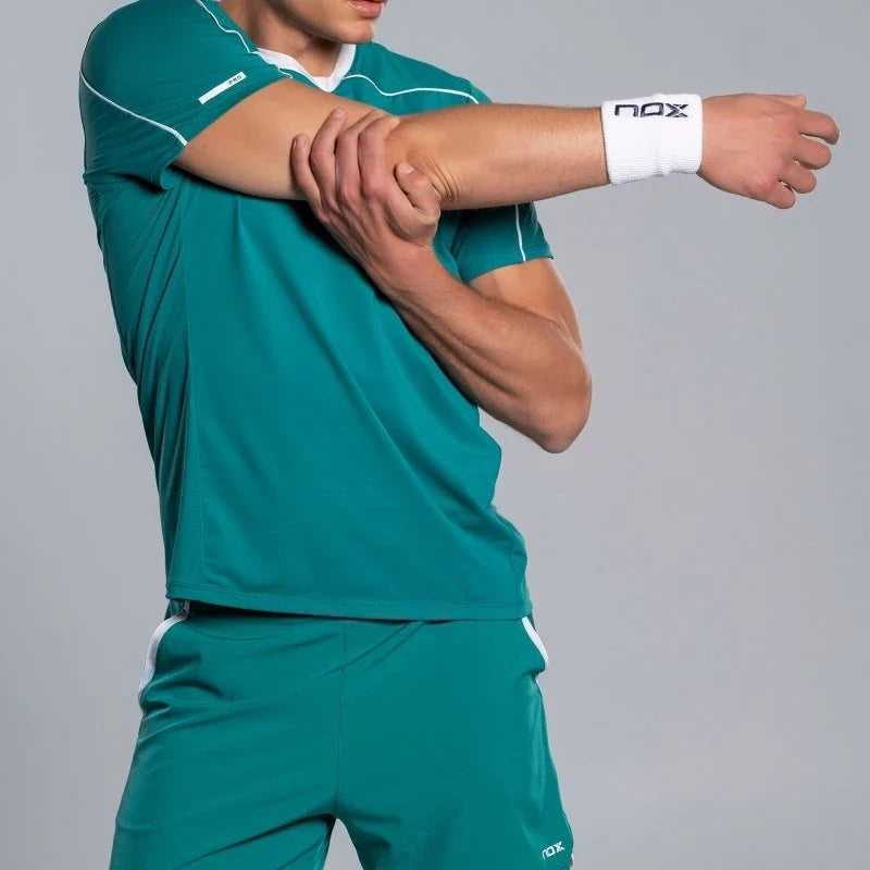 2026 Nox Pro men's padel shorts (Ivy Green) - worn with matching T-shirt, stretching